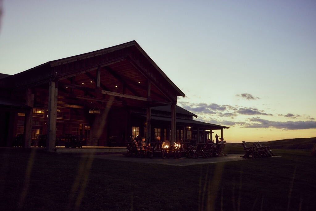 Luxury lodge with outdoor seating and firepit at sunset in Nebraska Sandhills.